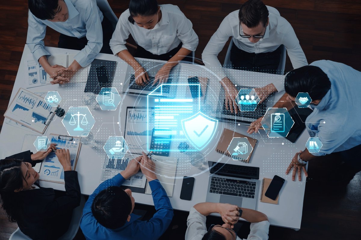 Team collaborating around a table with security and compliance icons overlaid