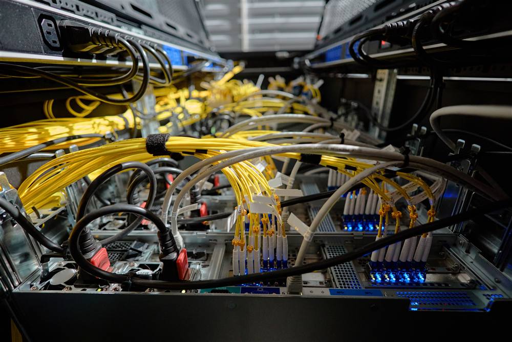 Organized fiber and copper patch cables terminated in a network rack