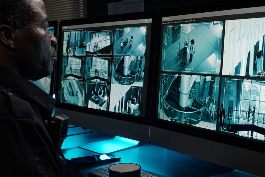 Security staff monitoring hotel camera surveillance feeds