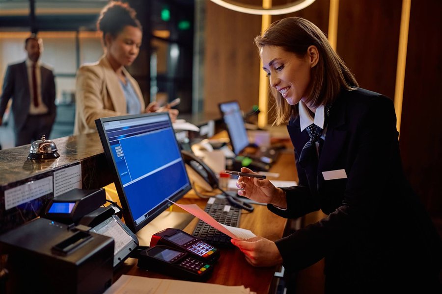Hotel front desk agent working at a check-in workstation