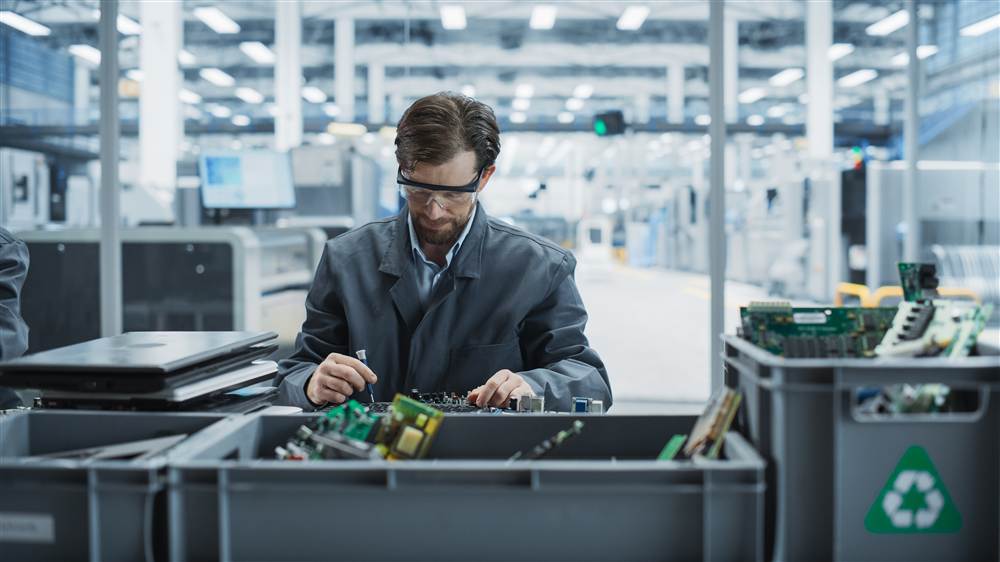 Technician processing IT hardware for secure decommissioning and recycling