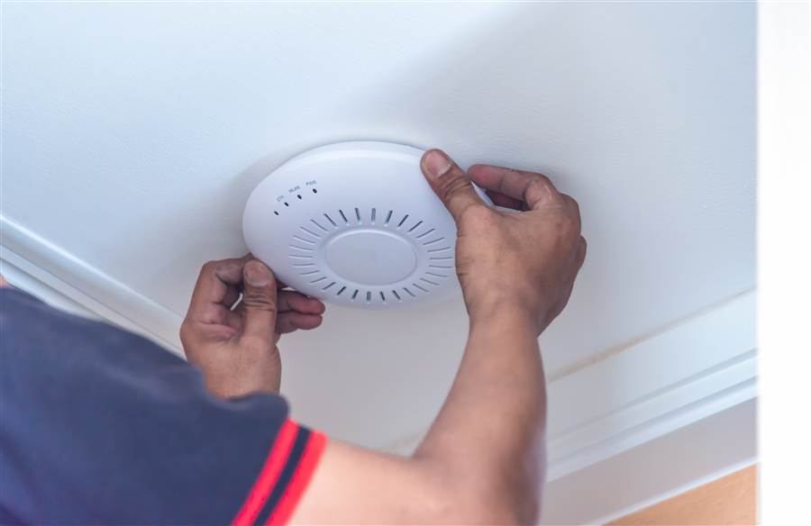 Technician mounting a wireless access point on a ceiling