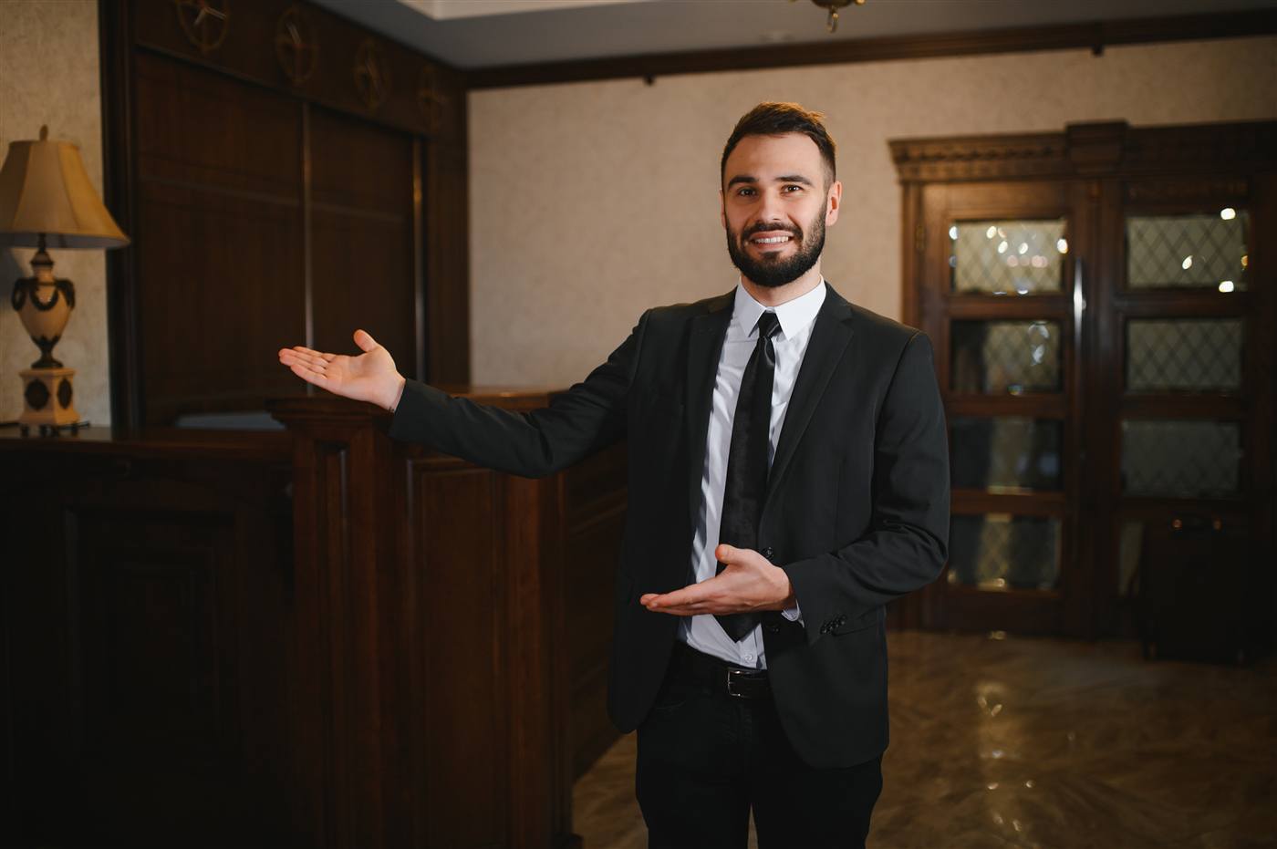 Hotel host welcoming guests at the front desk