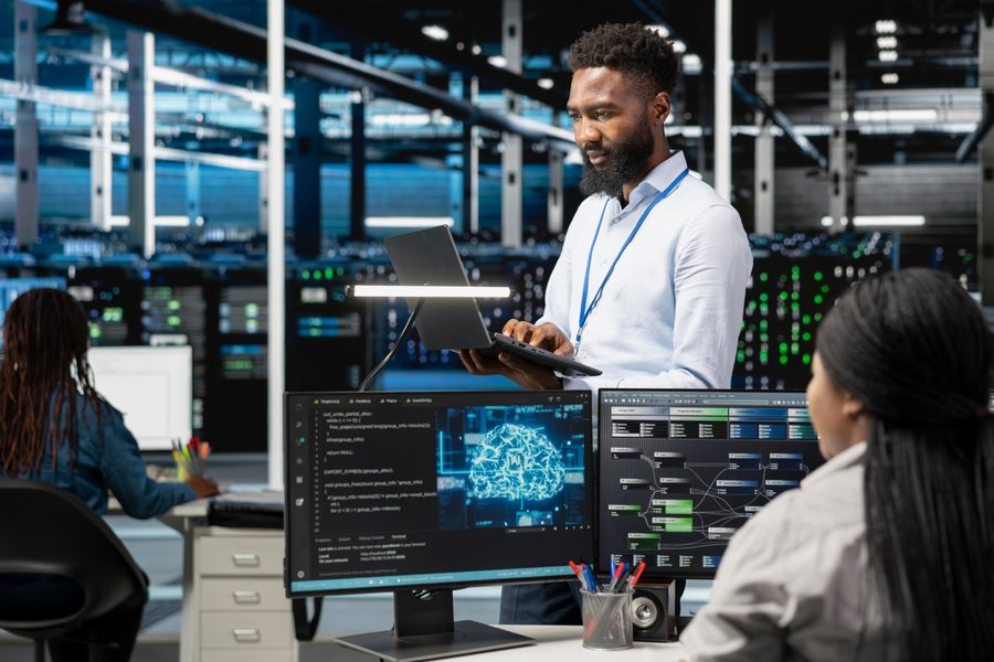 Technician managing servers and remote support software on multiple monitors